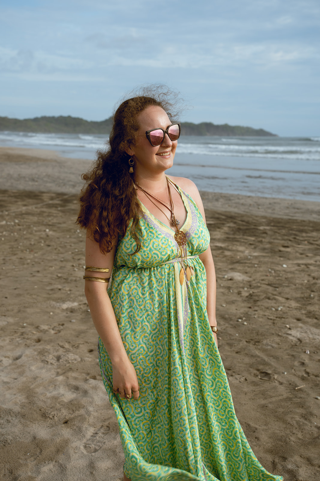 Teilnehmerin in grünem Kleid lächelt am Strand